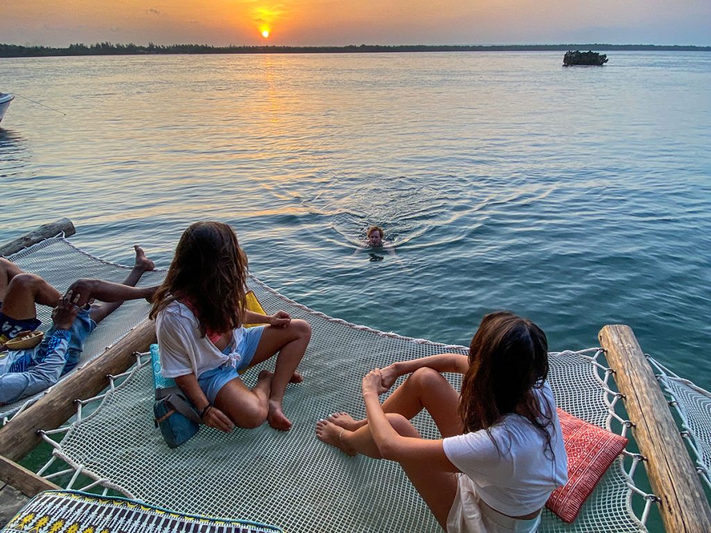 Temple Point Resort au Kenya. Contemplation du coucher de soleil en famille avec des enfants sur un filet d'habitation, dock hammock au dessus de la mer